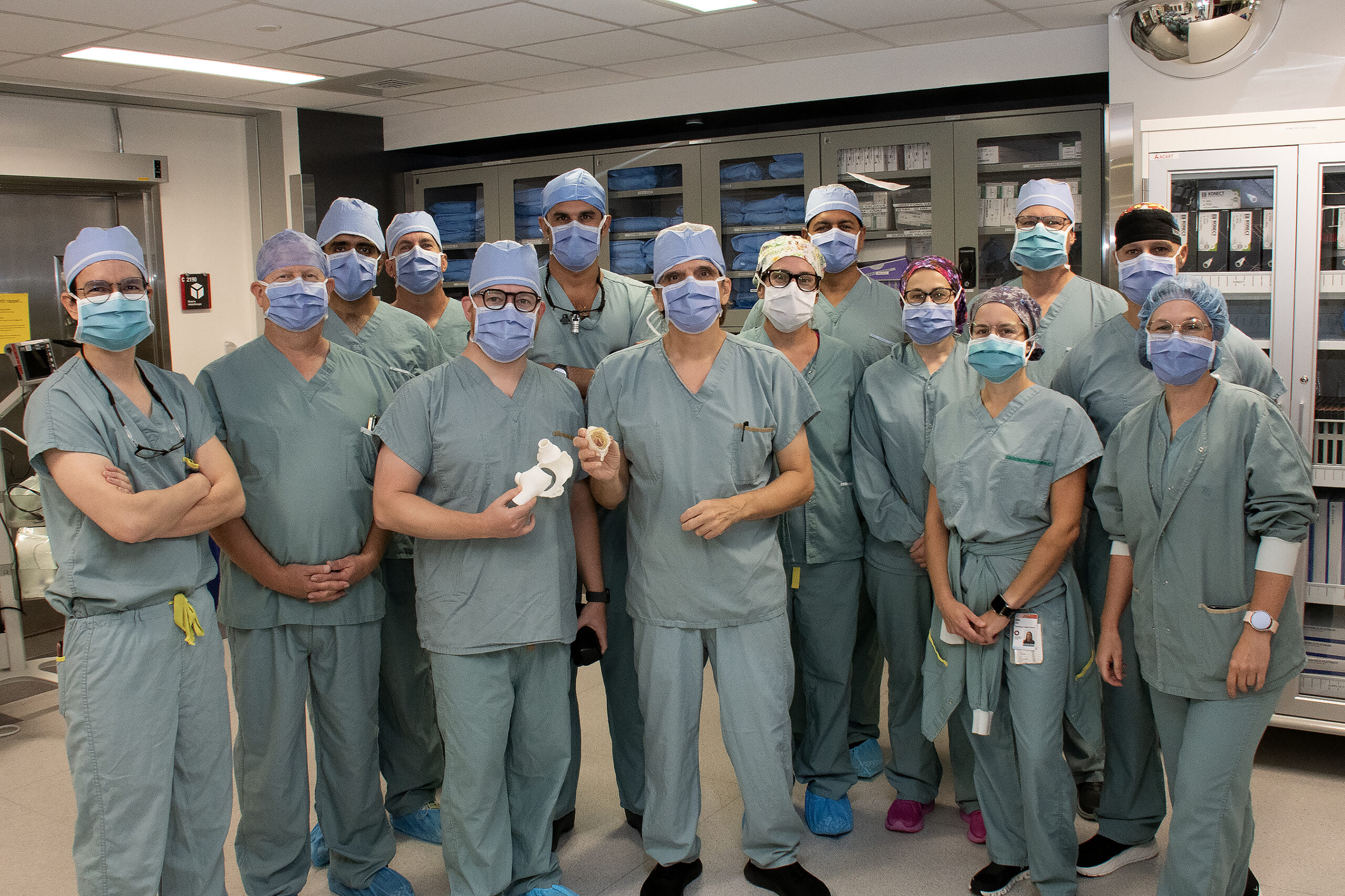 Photo d'équipe avec plusieurs personnes habillés en tenue de bloc opératoire