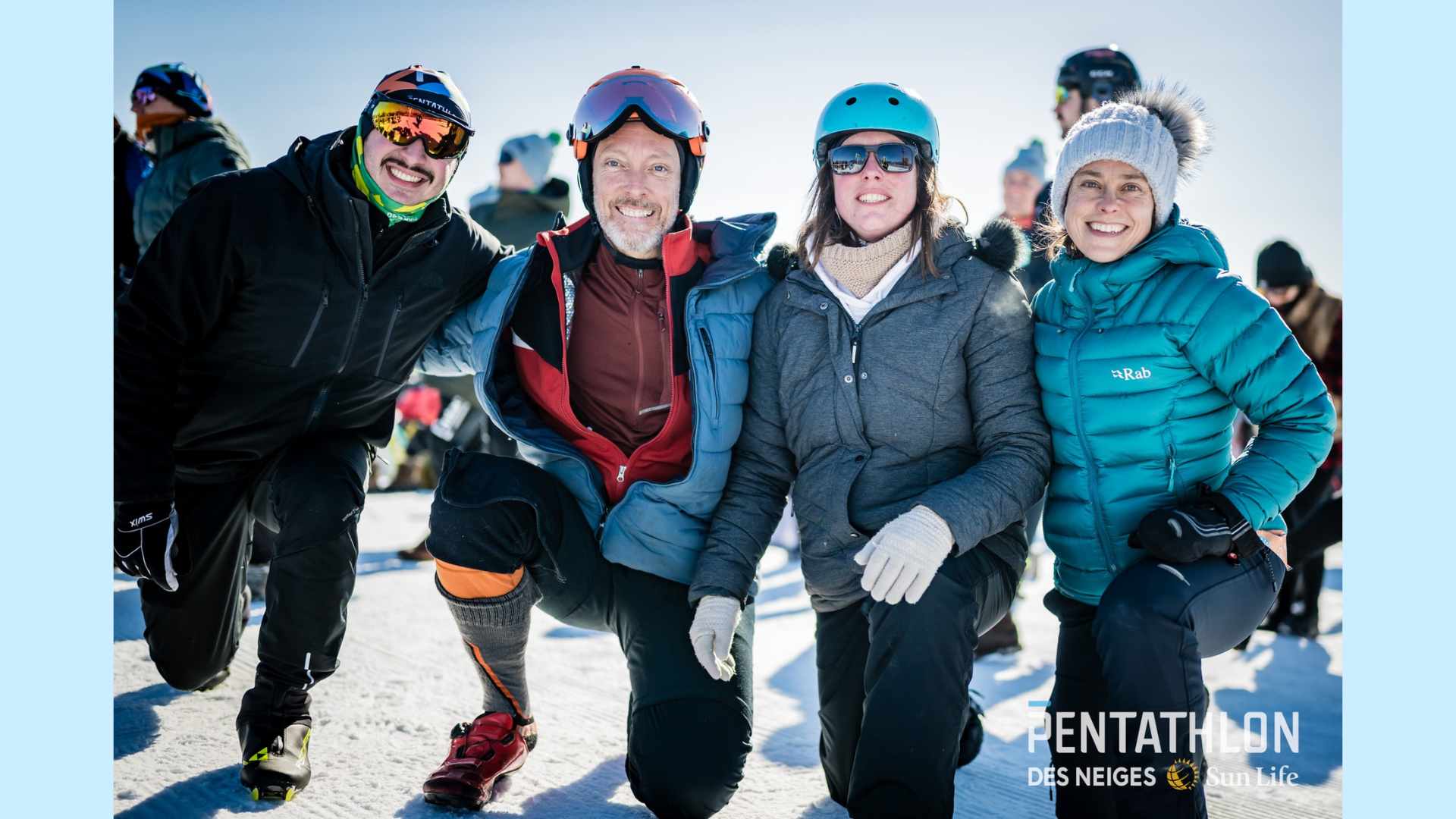4 personnes côte à côte, employées de l'Institut et habillées pour l'hiver, à l'extérieur et qui sourient lors du Pentathlon des neiges